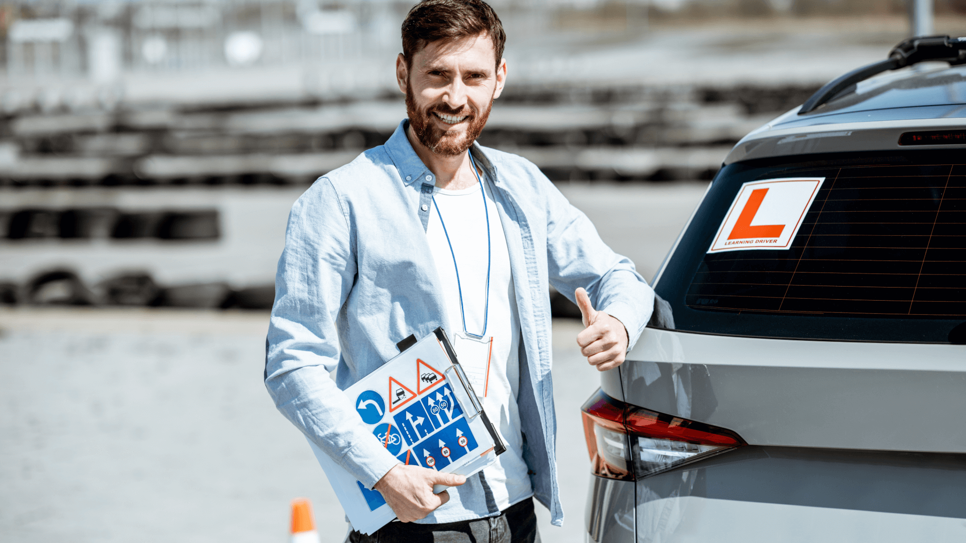 Approved driving instructor smiling next to learner driver vehicle